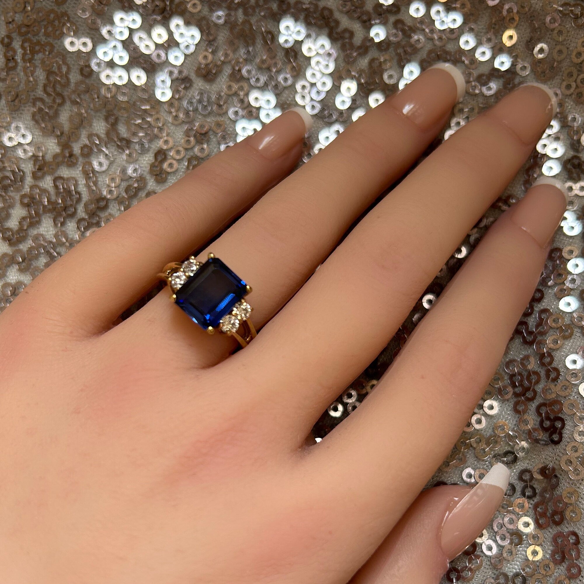 An absolute stunner, classic blue sapphire engagement ring with an emerald cut gemstone of your choice as it’s centre stone and with round cut clear quartz on the band to further accentuate it.